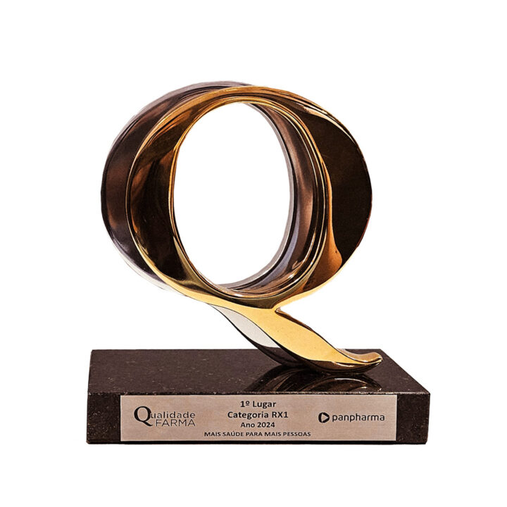 Photo of the first-place trophy for the Pharma Quality Award: the capital letter Q in gold on top of a granite base with the name of the award and the name of Biolab Farmacêutica.