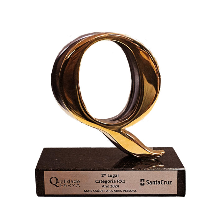 Photo of the first-place trophy for the Pharma Quality Award: the capital letter Q in gold on top of a granite base with the name of the award and the name of Biolab Farmacêutica.